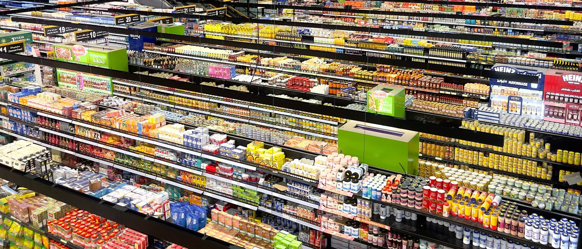 An aerial view of supermarket aisles filled with colourful packaged products.