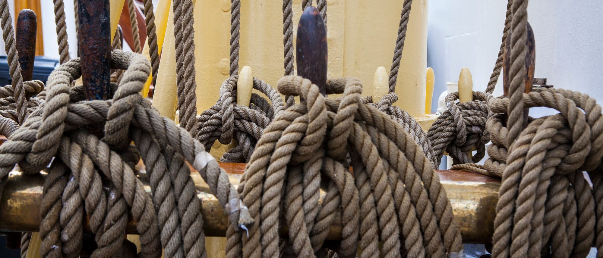 Thick brown ropes knotted tightly on the deck of a sailing ship.