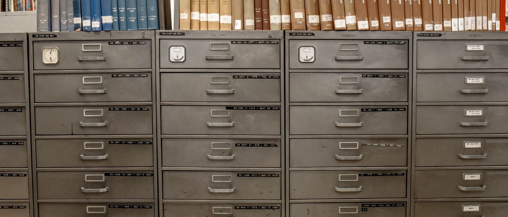Rows of grey steel filing cabinets and indexed drawers in a library.