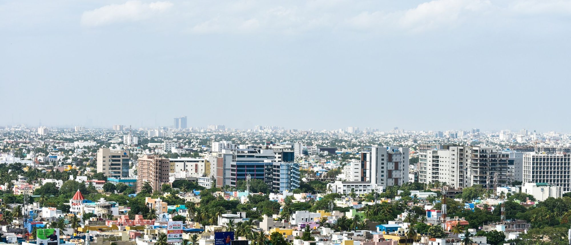An aerial view of tall apartment blocks in Chennai under a clear sky.