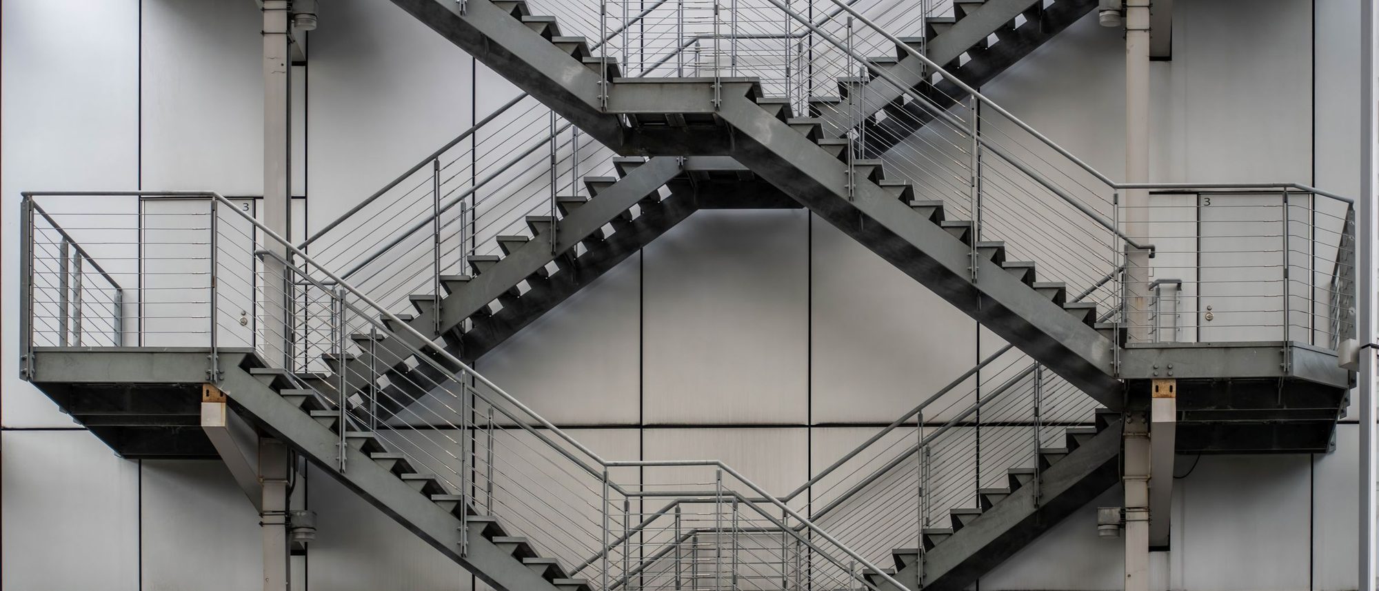 Metal staircases crossing one another on the outside of an industrial building in Tokyo.