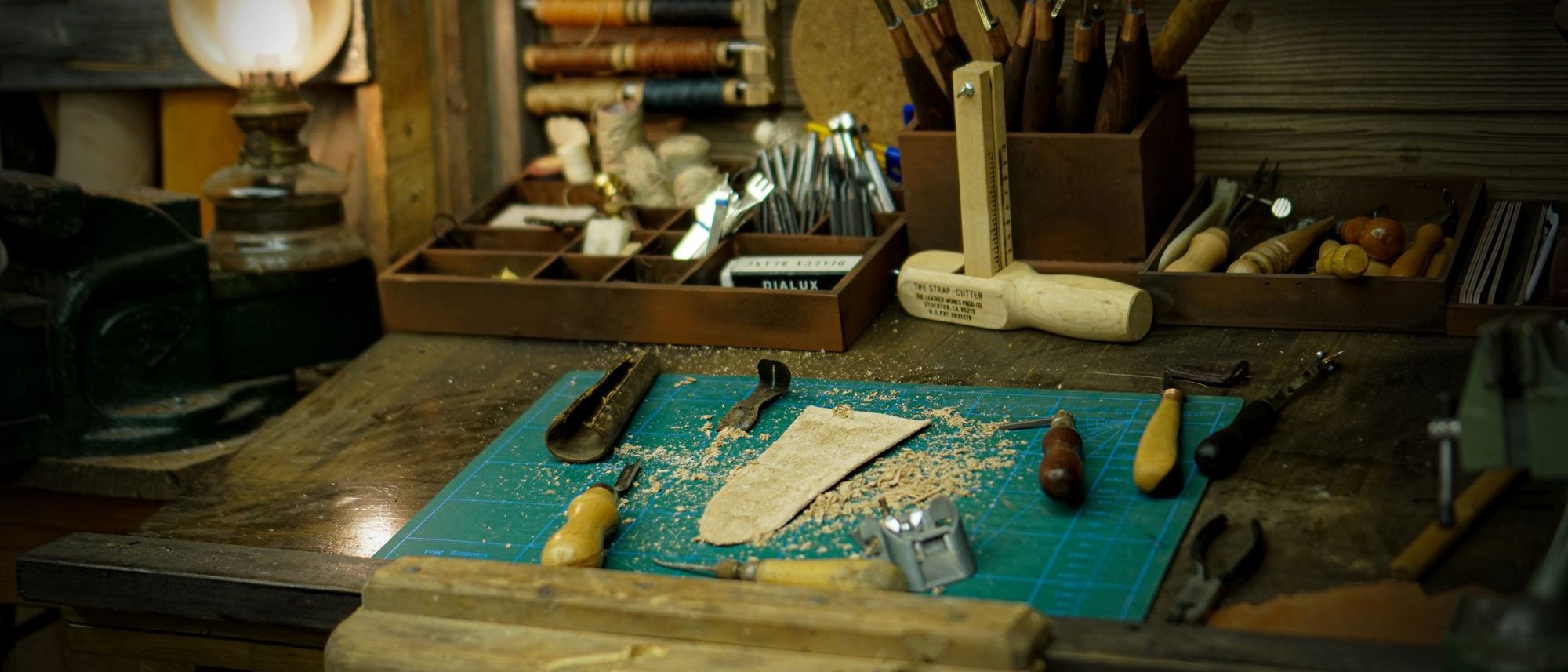 A vintage workshop table laid with hand tools and wooden parts.