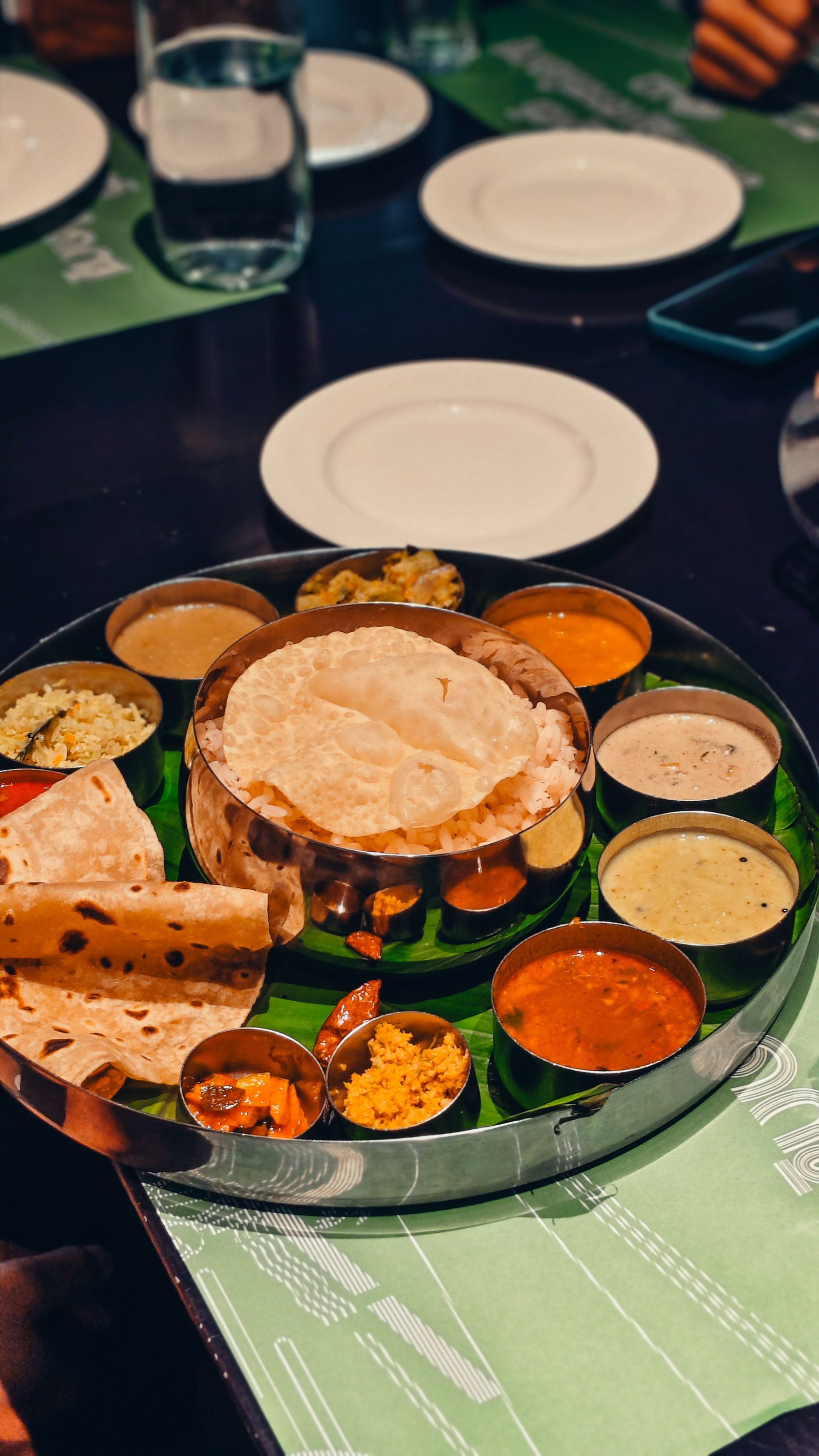 An Indian thali with rice and several small bowls of different dishes on one plate.