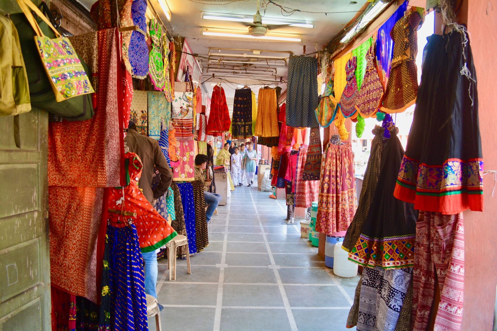 Traditional clothing and textiles hung on display at a market in Jaipur.