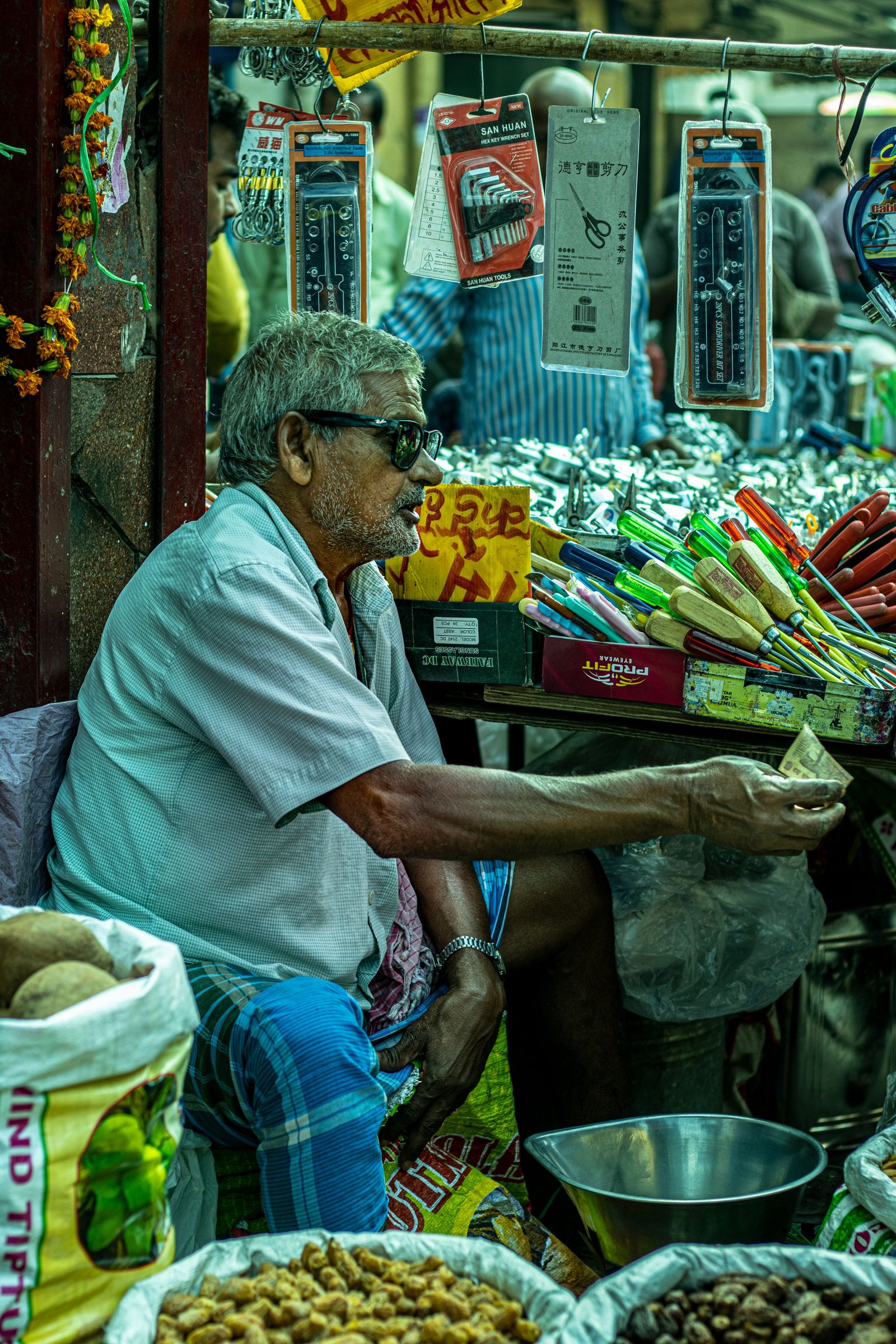 An elderly man sells vegetables and fruit from a market stall in Delhi.