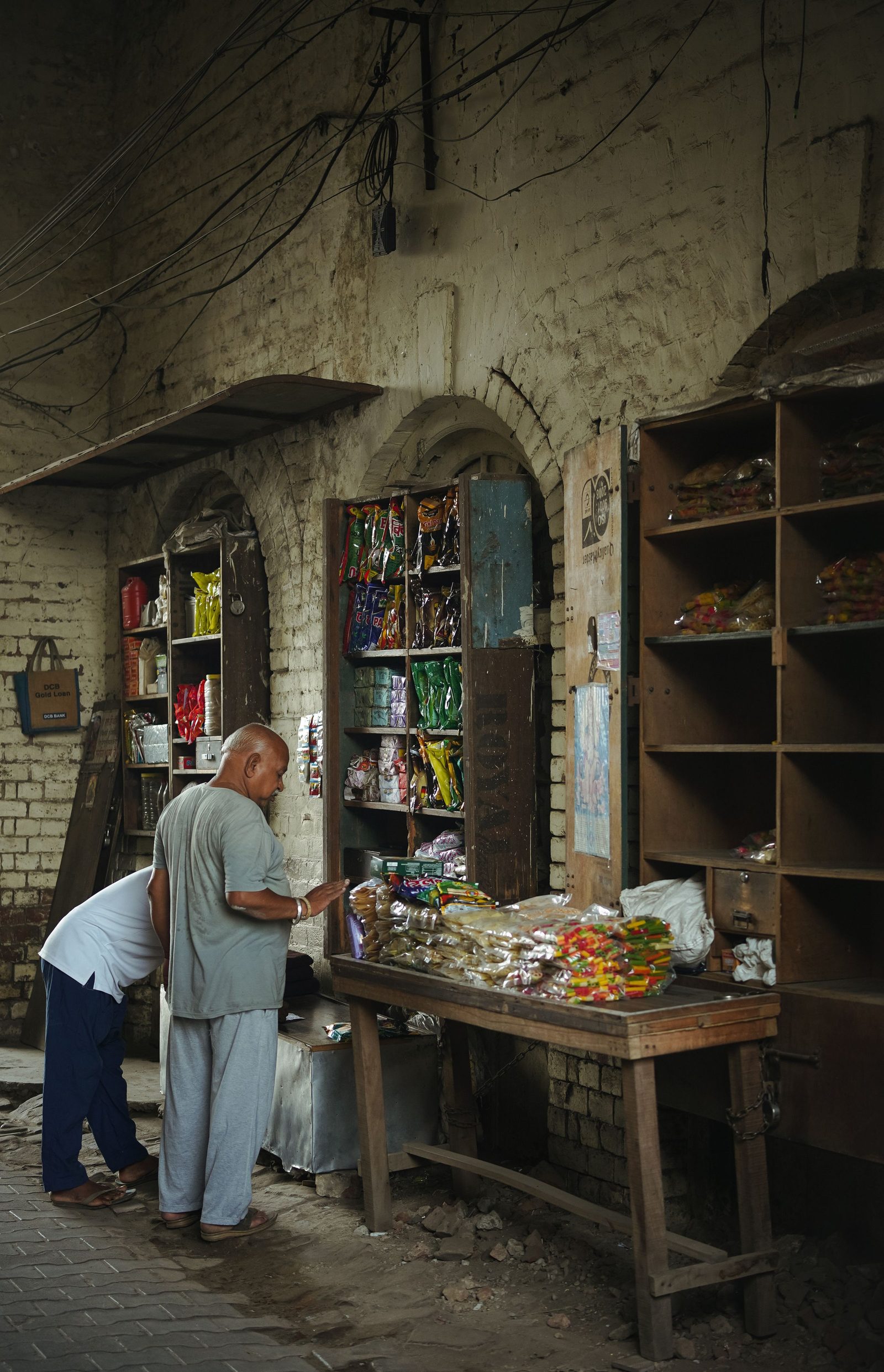 Two men look over goods at a small street shop in Moga in Punjab.