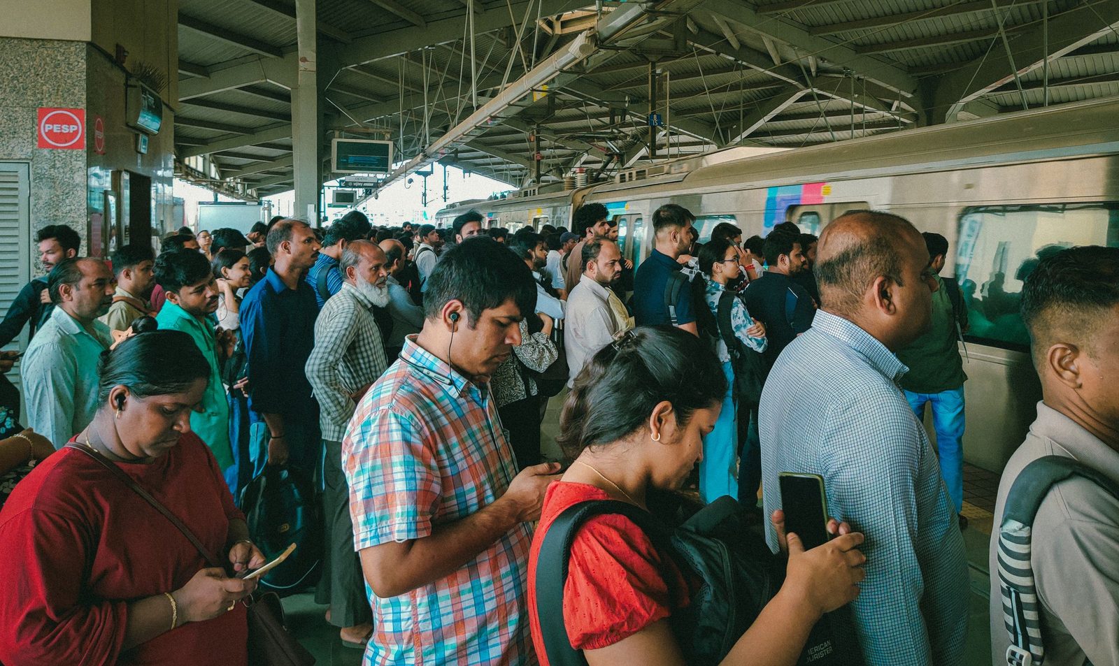 Commuters waiting on a crowded Mumbai railway platform.