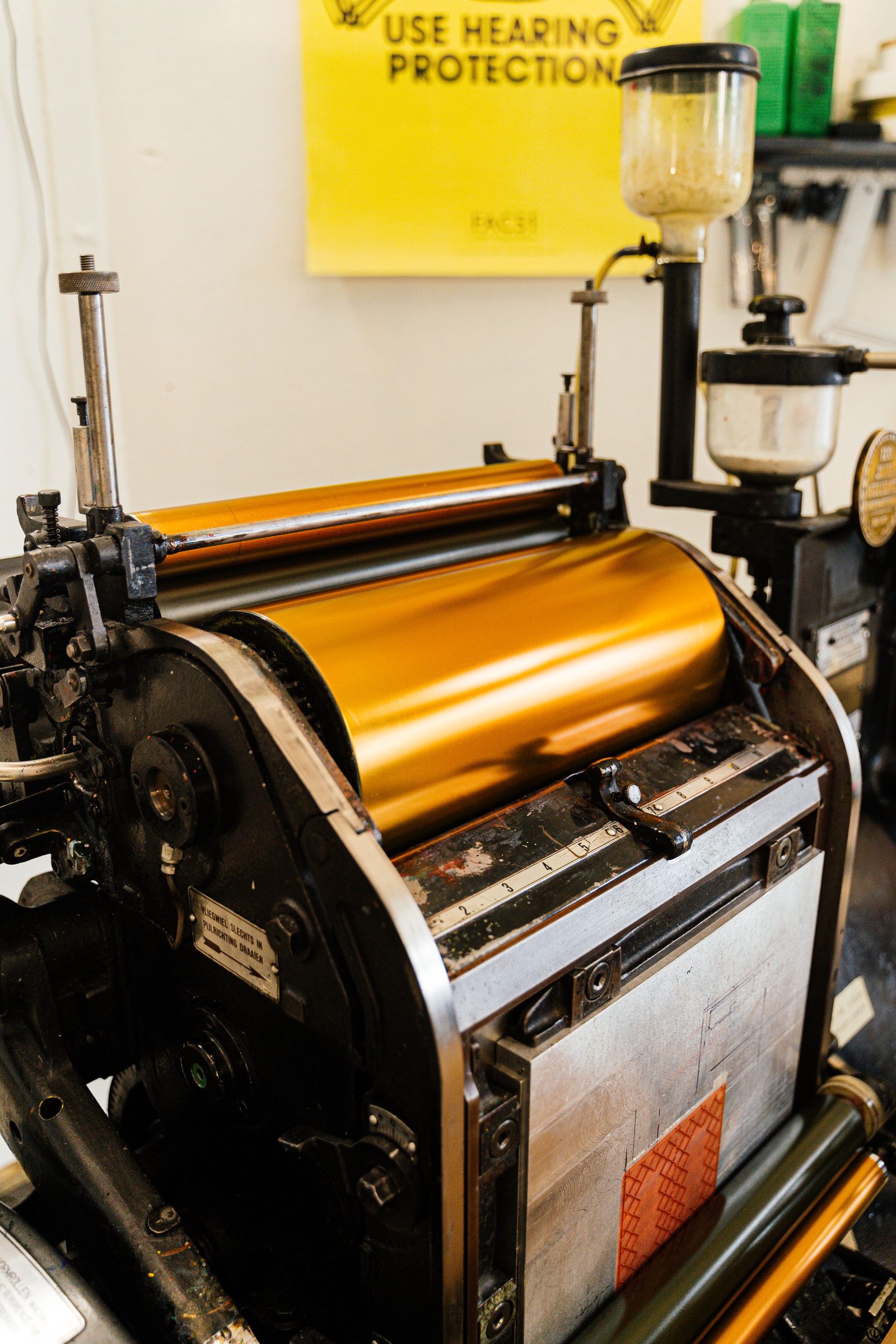 Close view of the brass rollers of an old printing press.