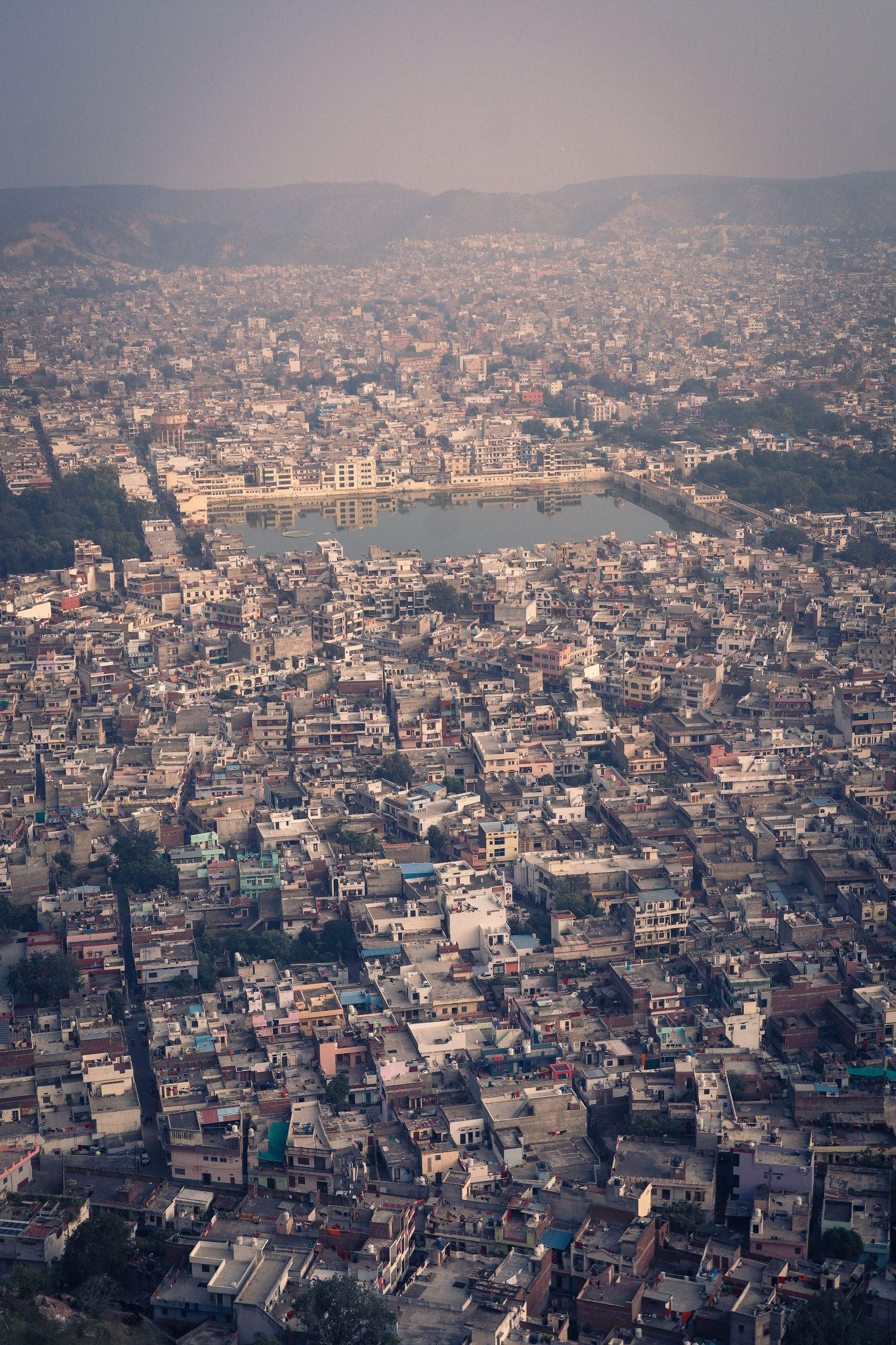 An aerial view of dense housing around a lake in Jaipur.