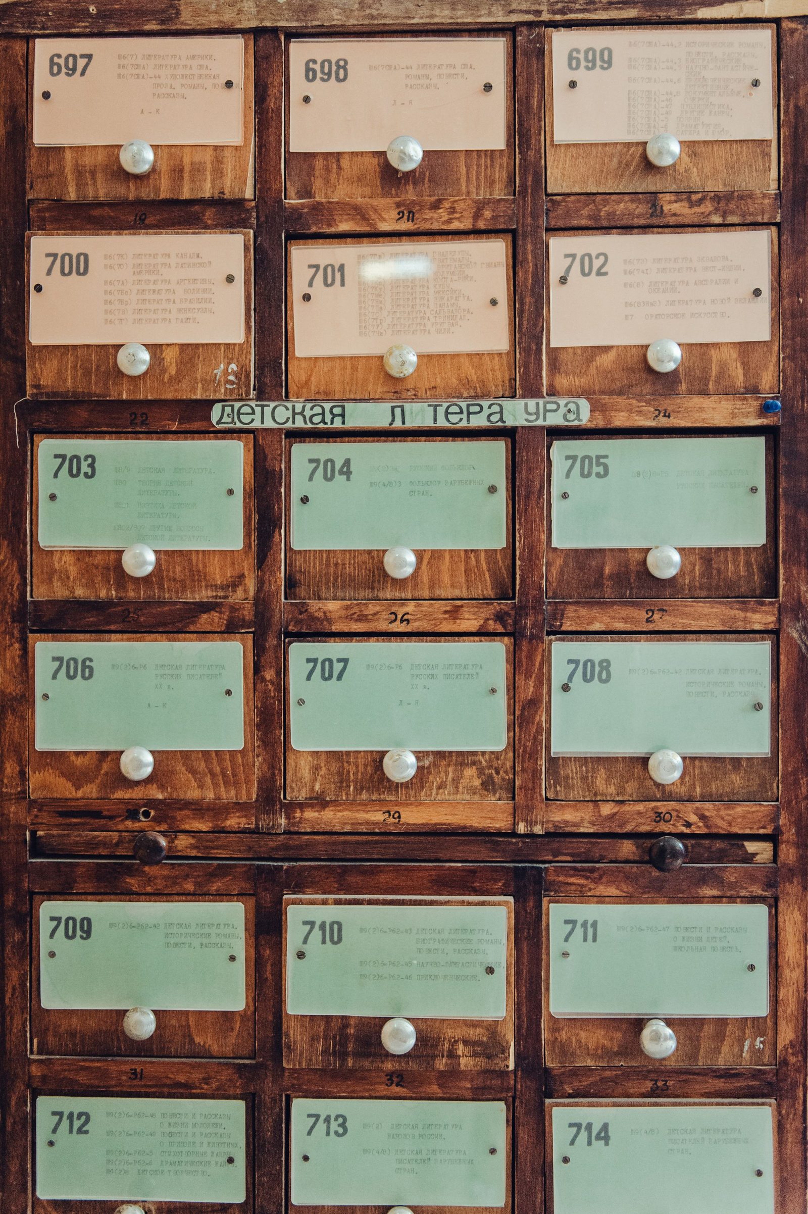 Rows of wooden card catalogue drawers in a library.