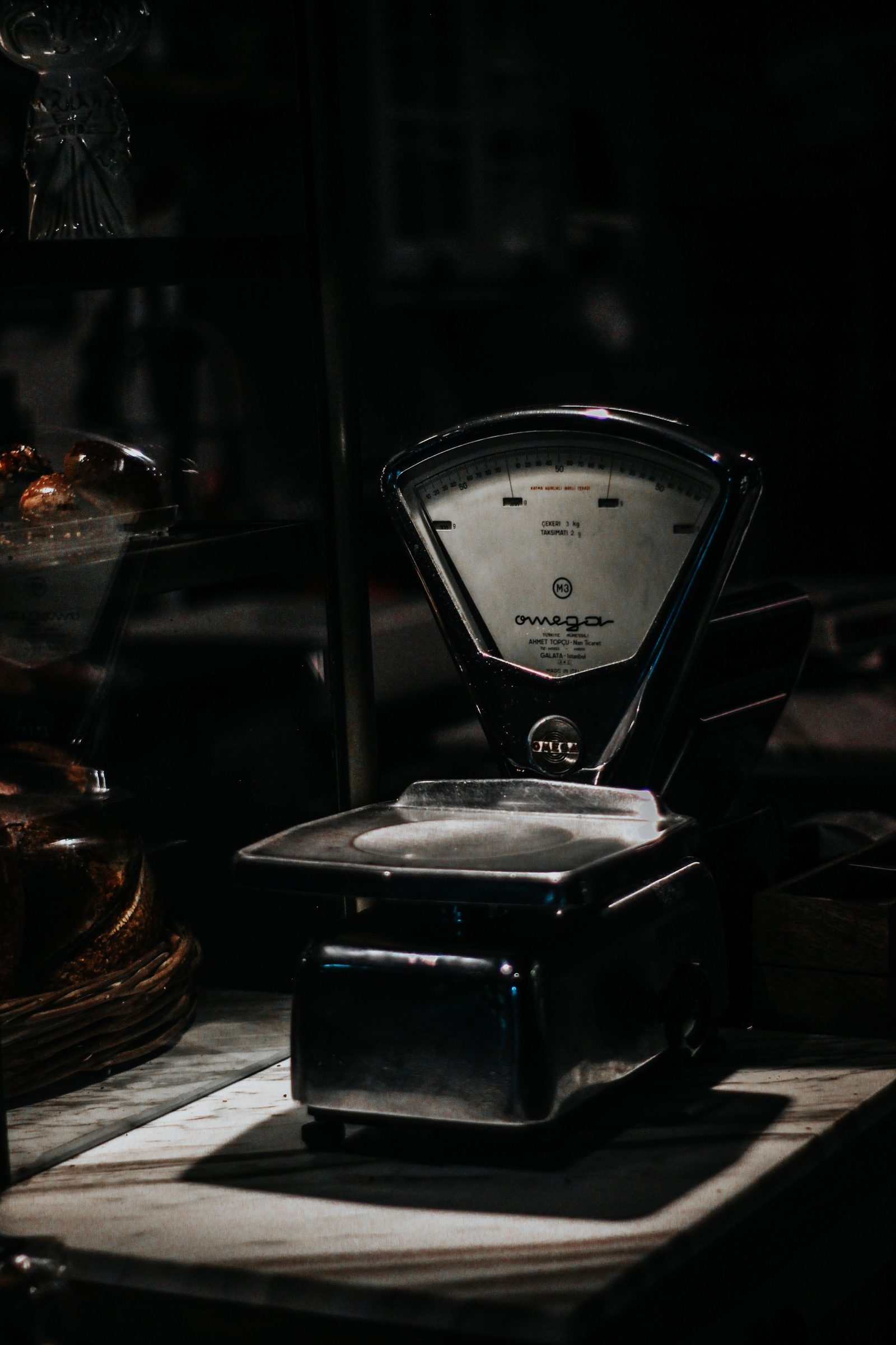 An old analogue shop scale stands under low light in an antique store.