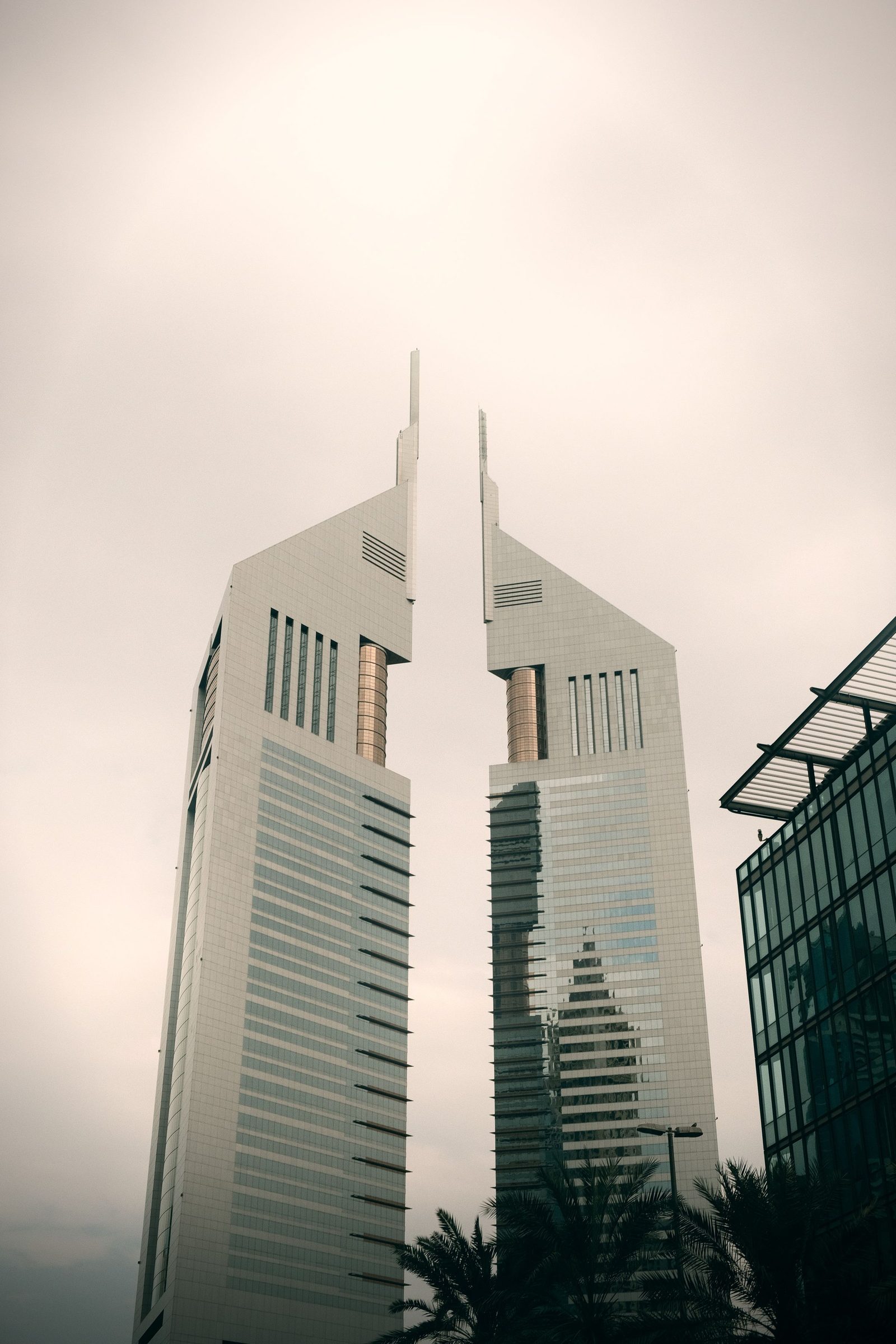 The two Emirates Towers in Dubai rise against the sky.