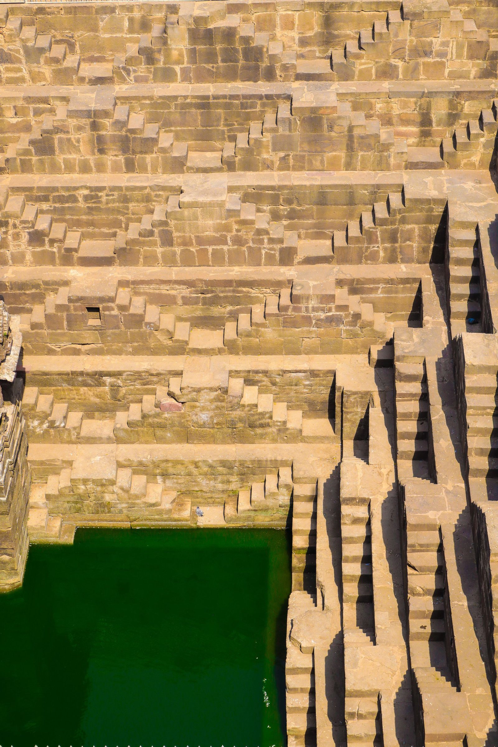 Geometric flights of stone steps on the walls of the Chand Baori stepwell at Abhaneri in Rajasthan.