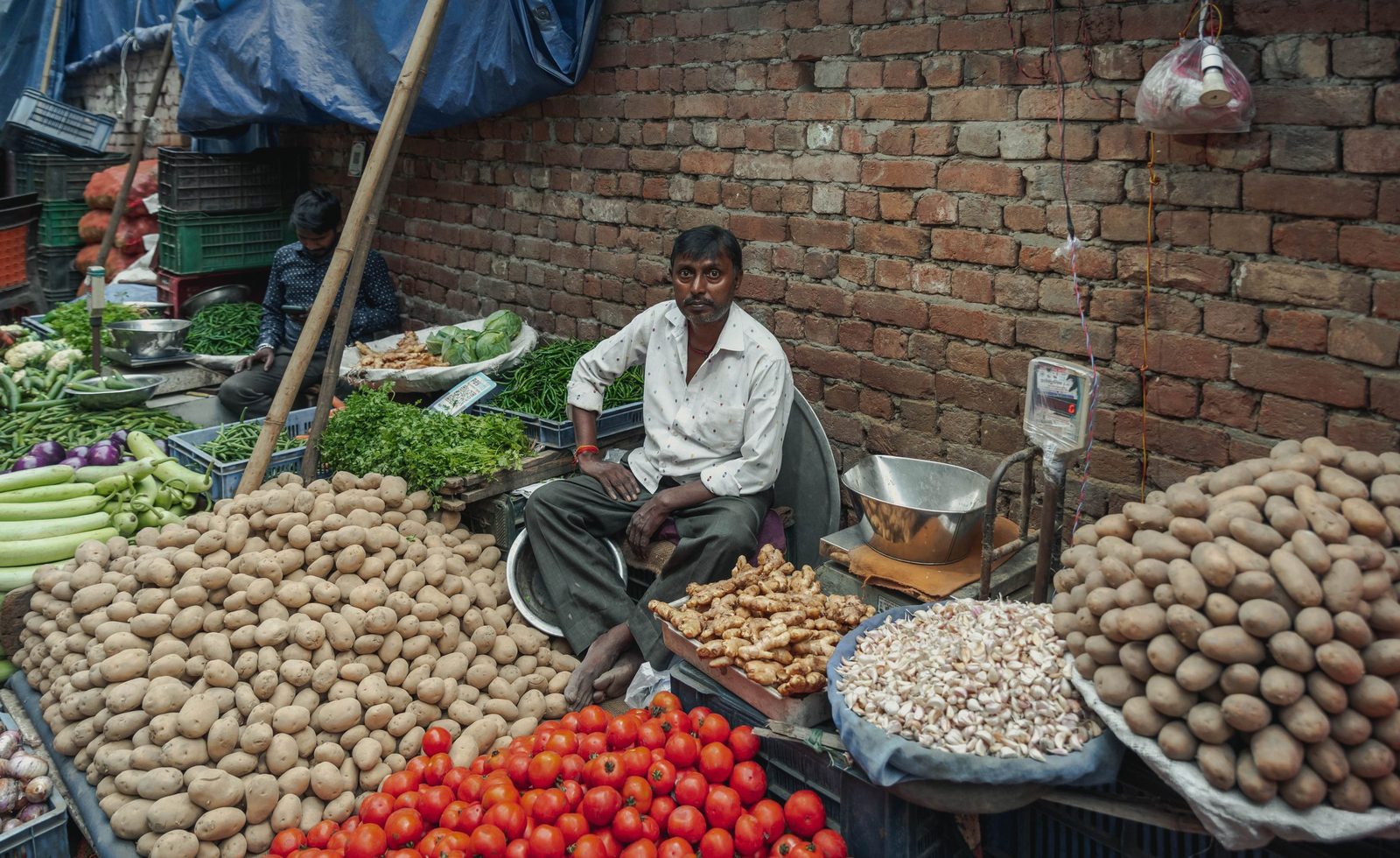 A vegetable stall in a Delhi street market piled with fresh produce.