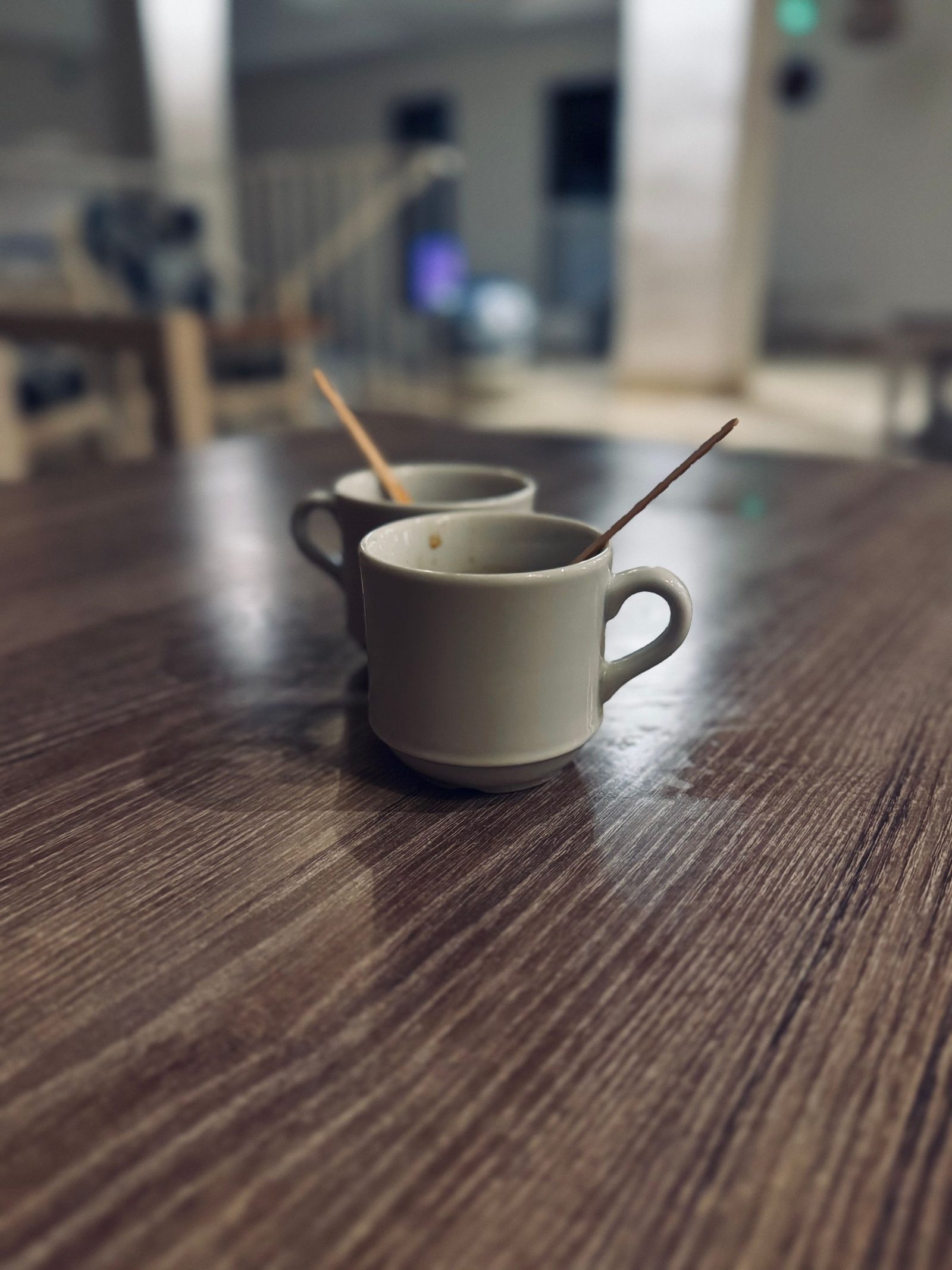 Two small cups of coffee on a rustic wooden table.