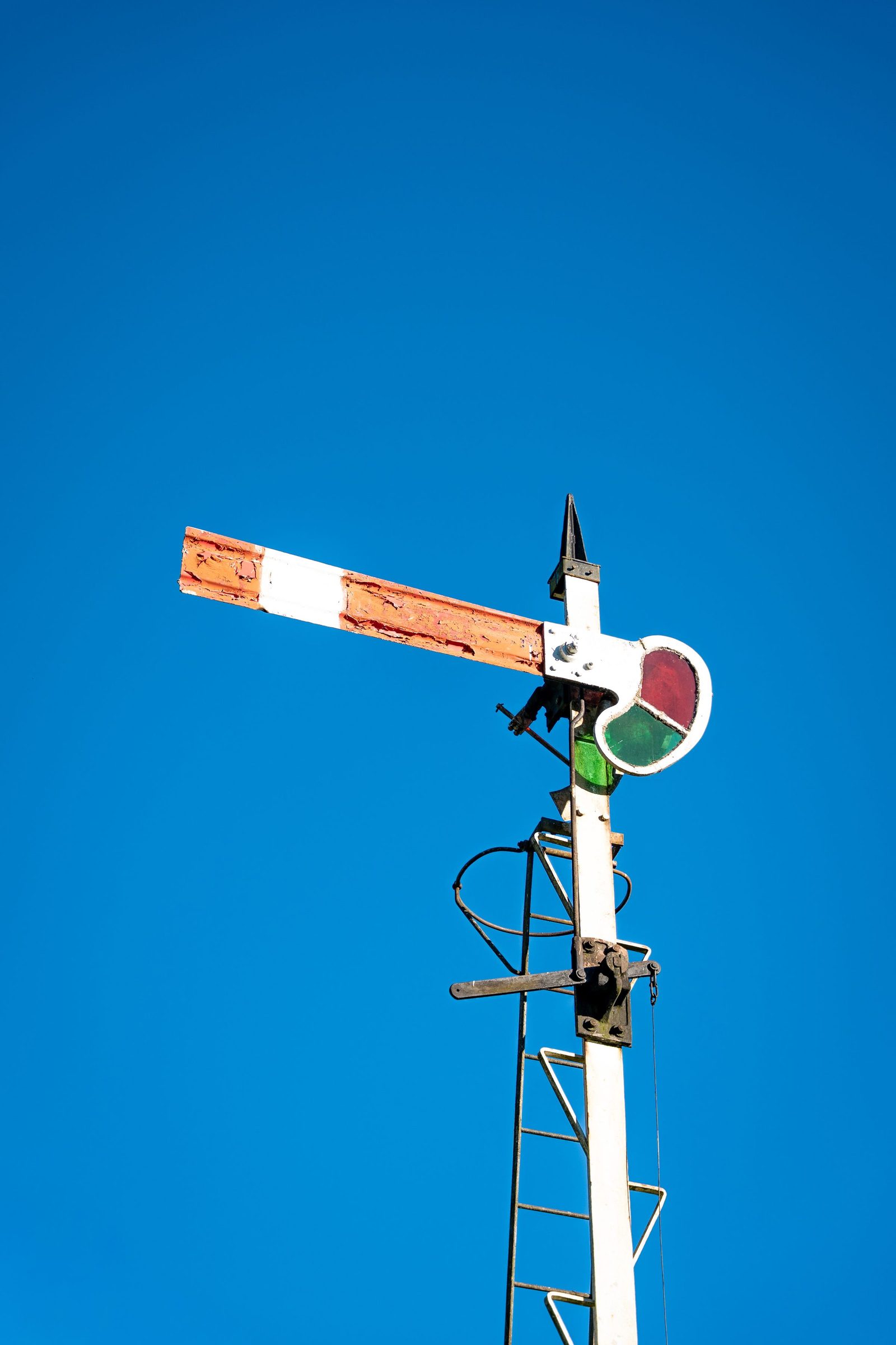 A vintage semaphore railway signal stands against a clear blue sky in Sri Lanka.