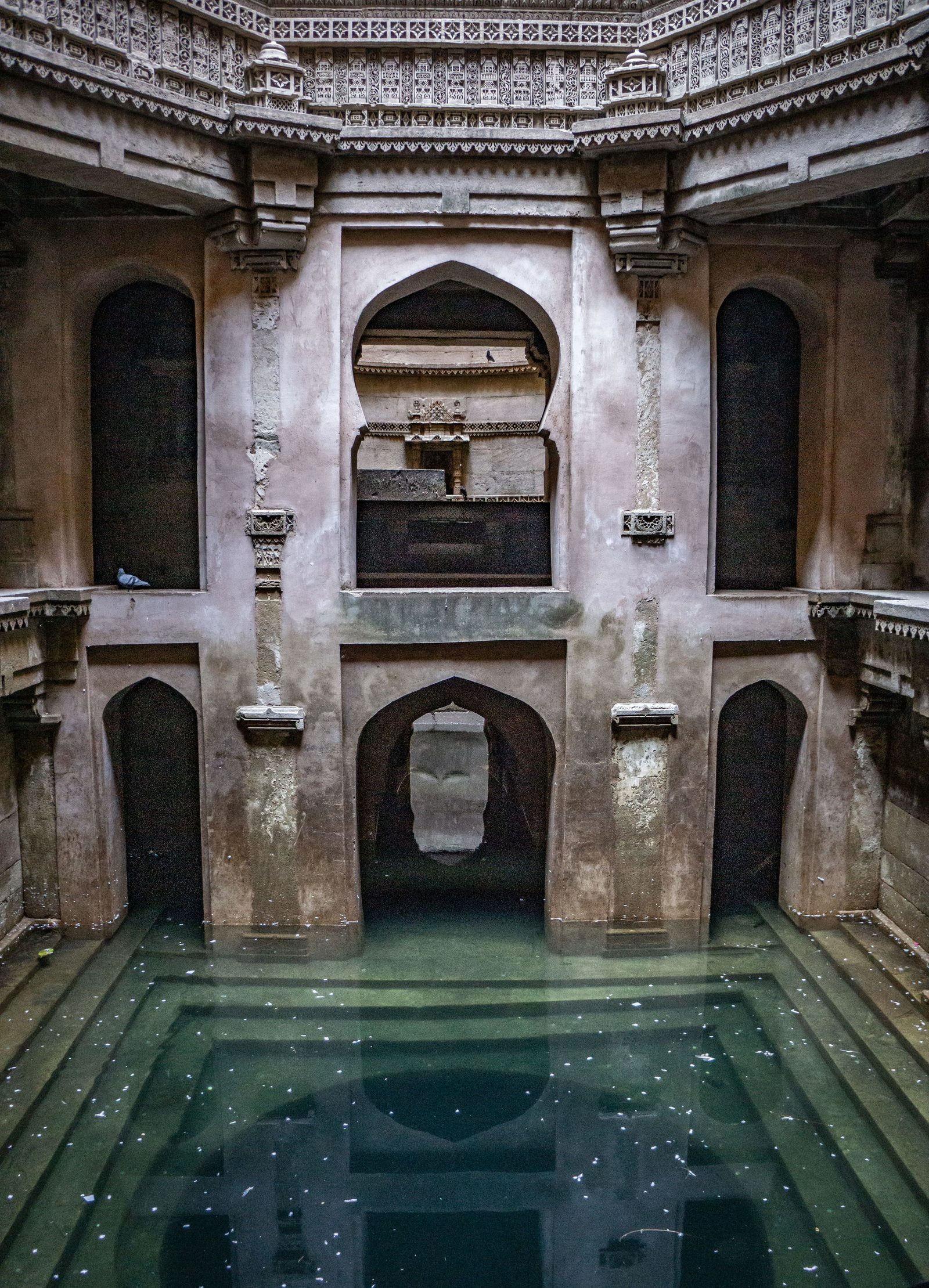 Still water lies at the bottom of the carved shaft of the Adalaj stepwell in Gujarat.