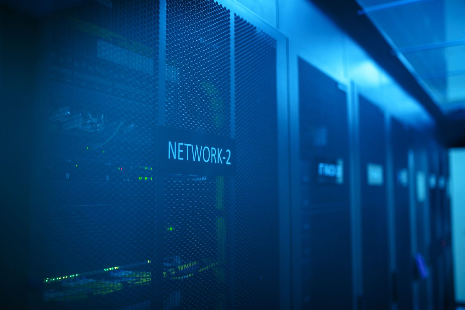 A server room with racks of network equipment under blue light.