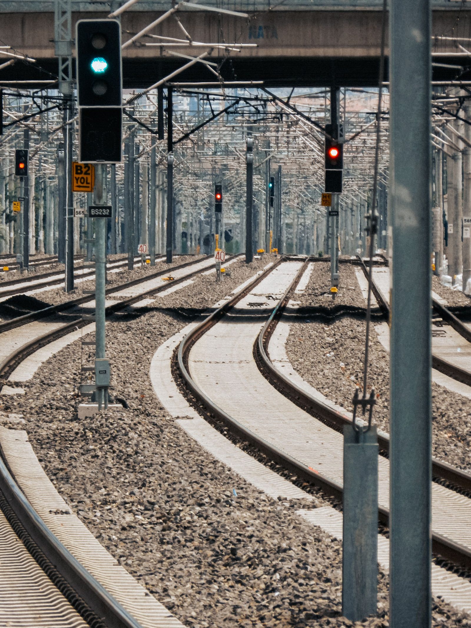 Curved railway tracks and signals at an urban station.