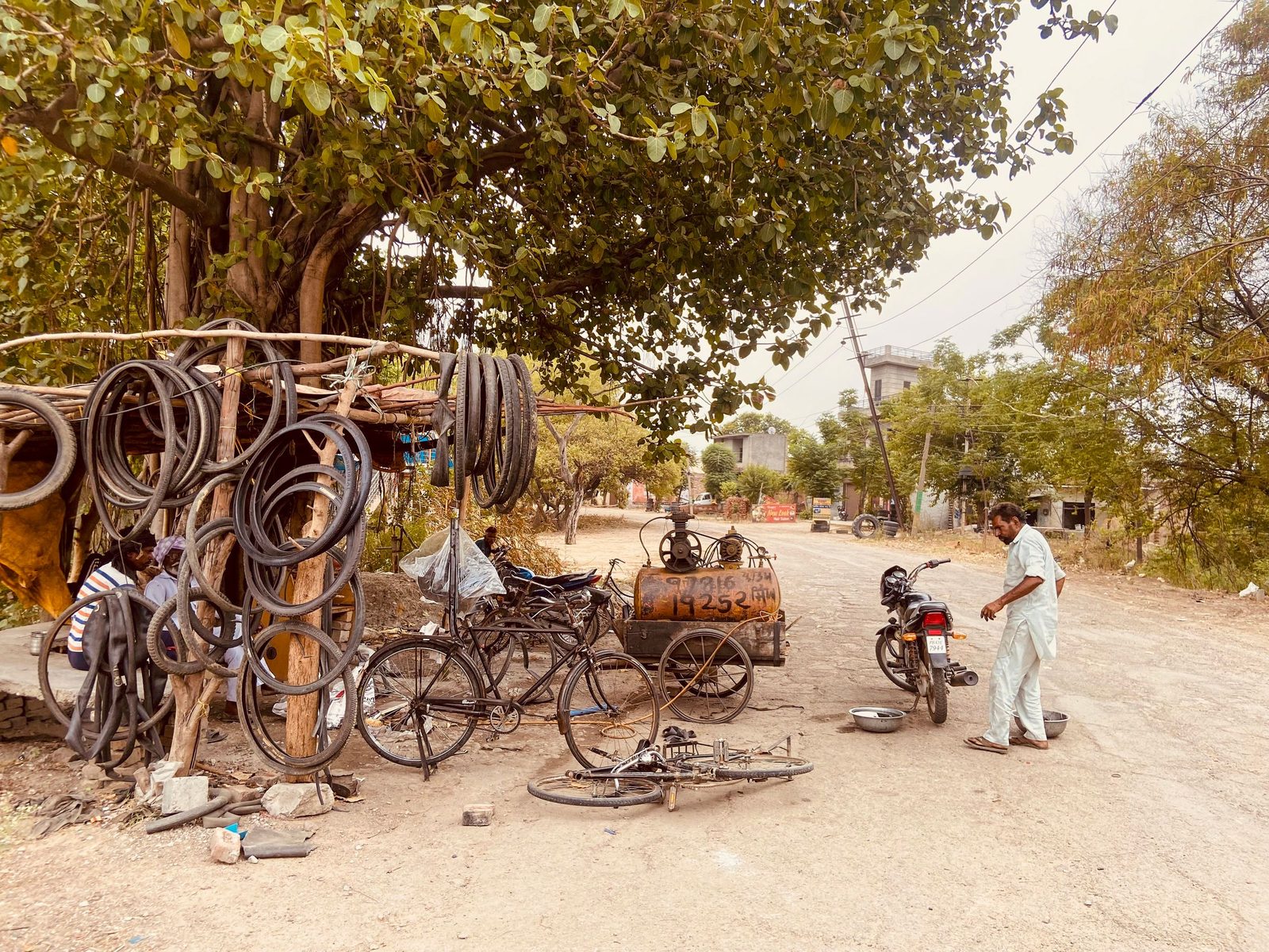 A man repairs bicycles at a roadside stall under a tree in Neelon Khurd in Punjab.