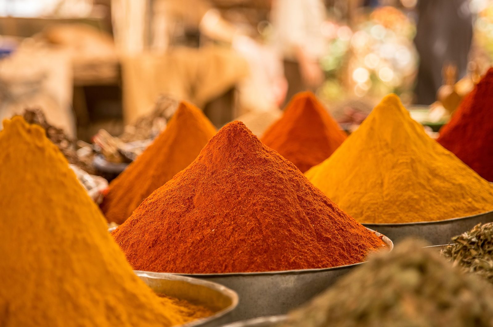 Mounds of coloured powdered spices on a market stall.