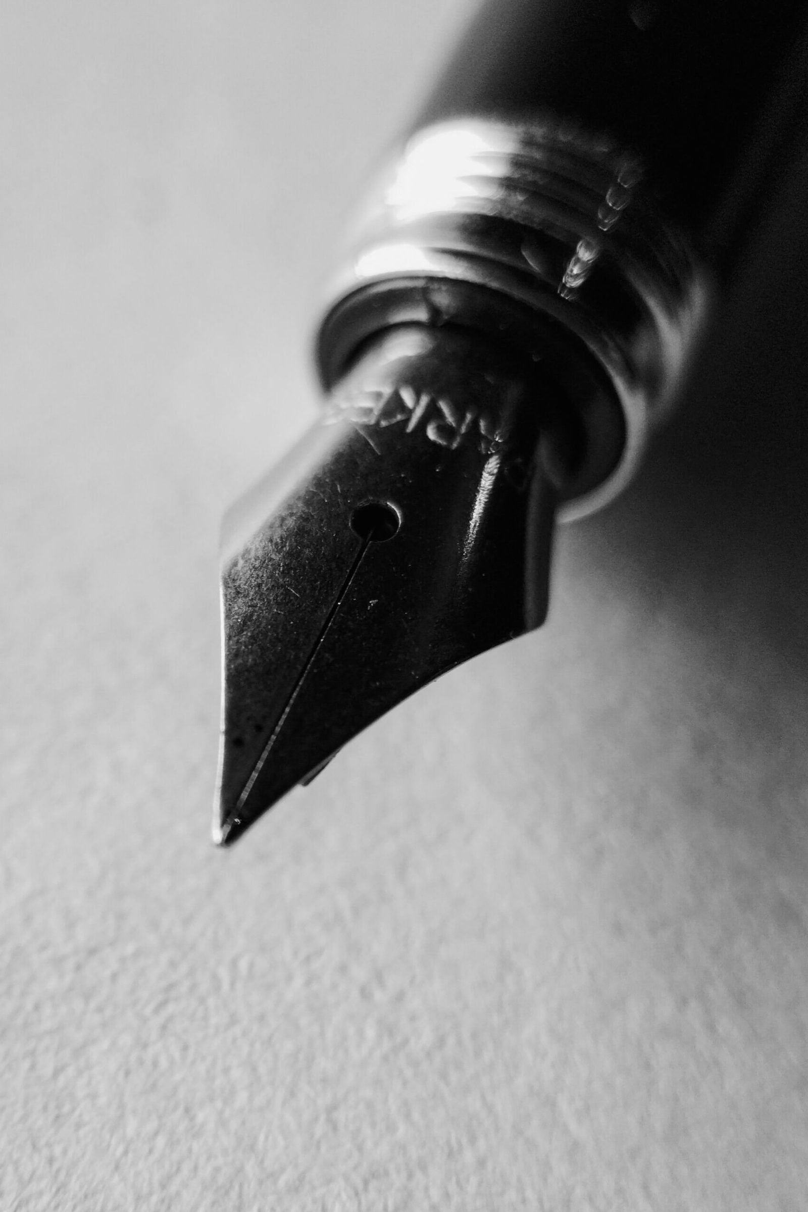A fountain pen nib in close-up in black and white.