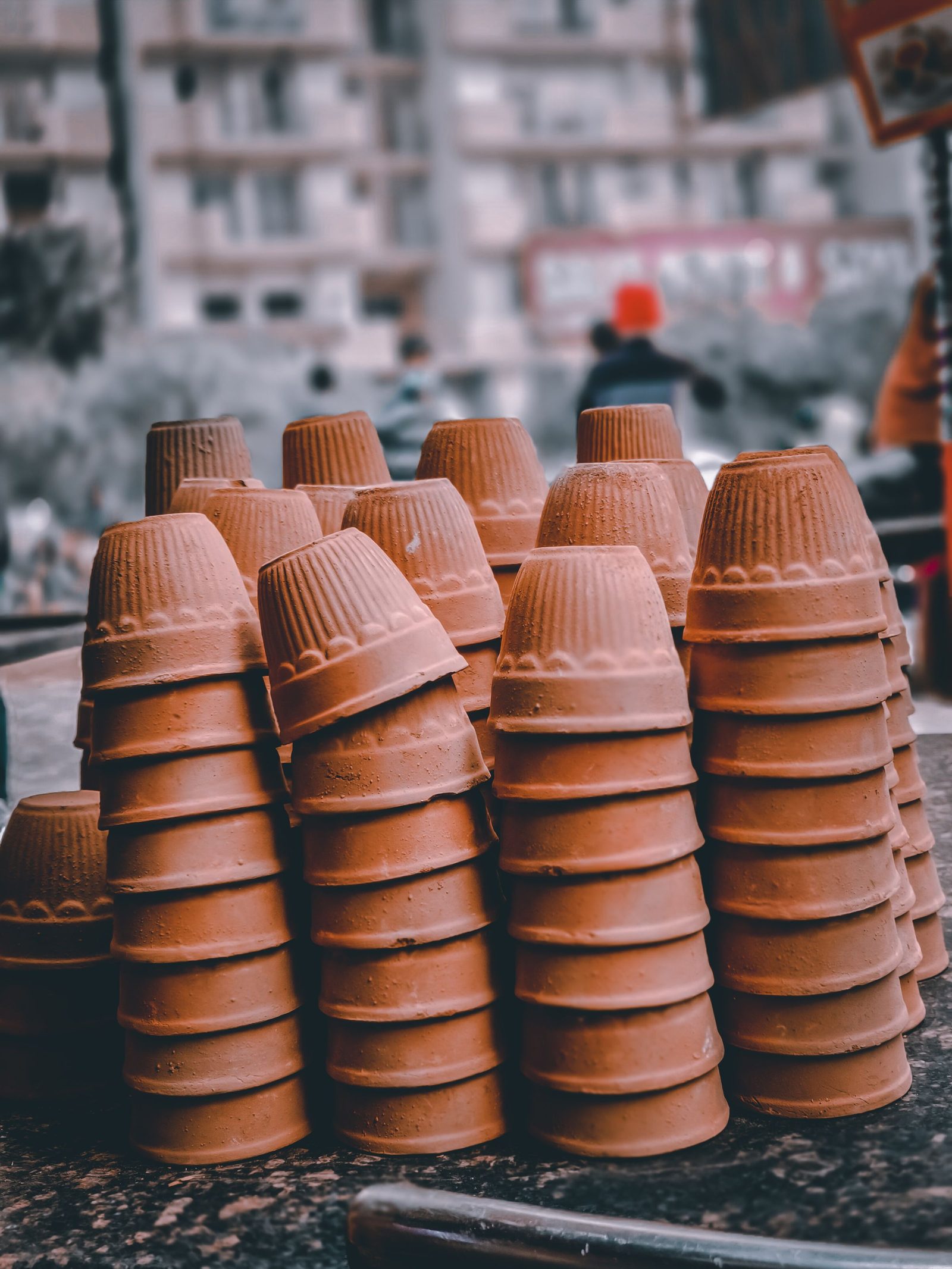 Clay cups stacked in tall columns at an outdoor market in Ghaziabad.