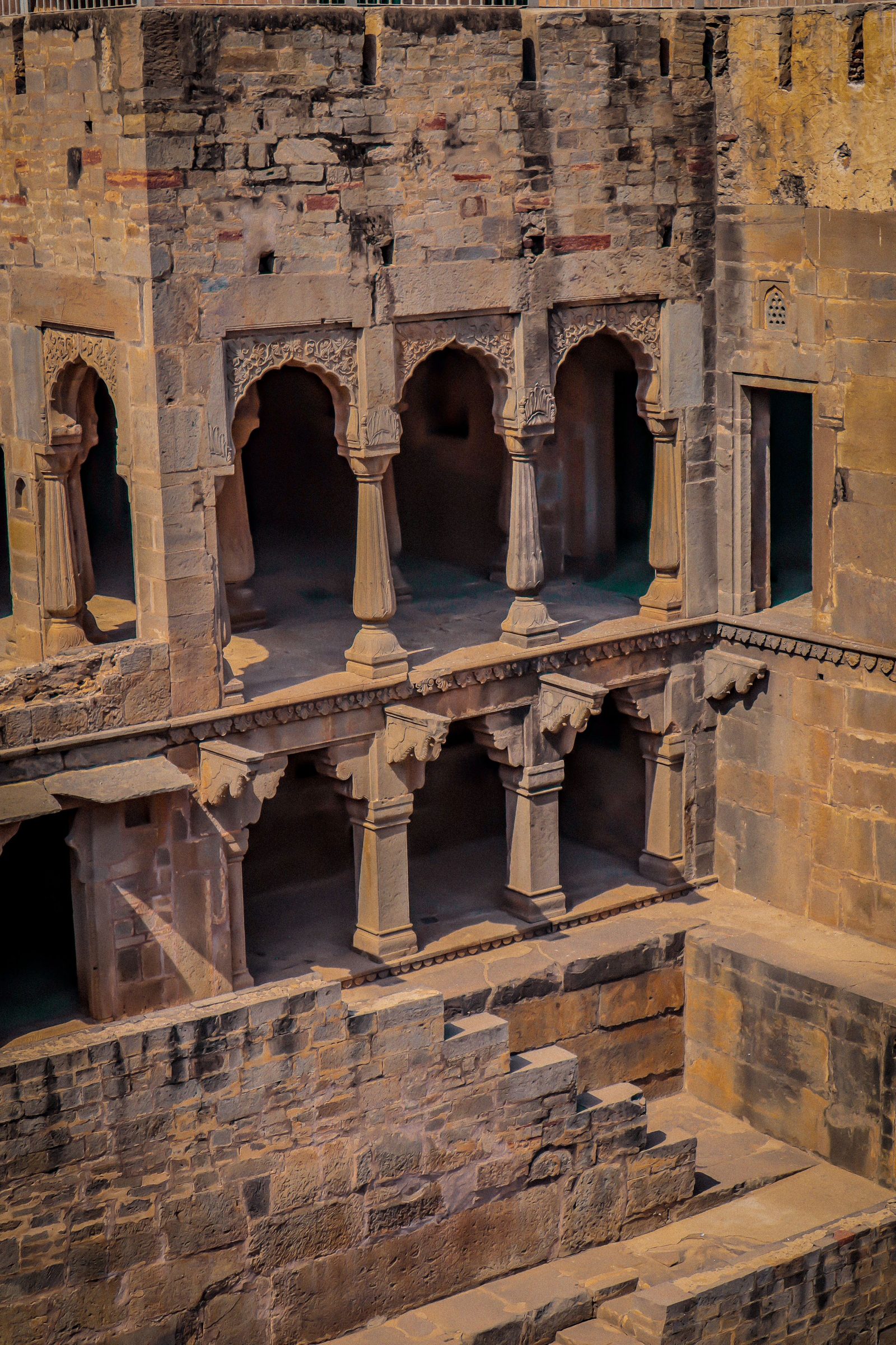 The stepped walls of the Chand Baori stepwell in Rajasthan descending towards the water.