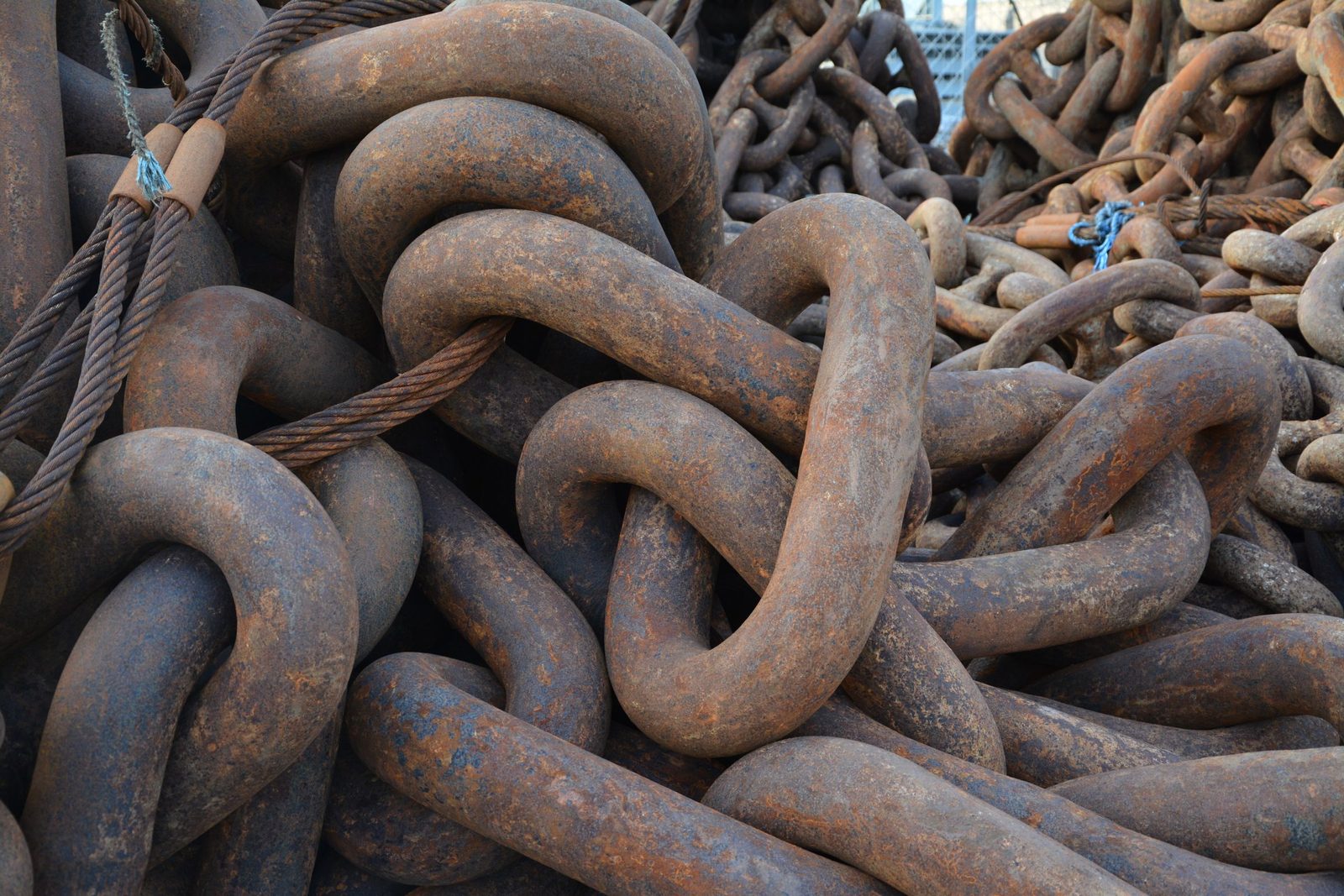 Heavy rusty chains lie intertwined in close-up.