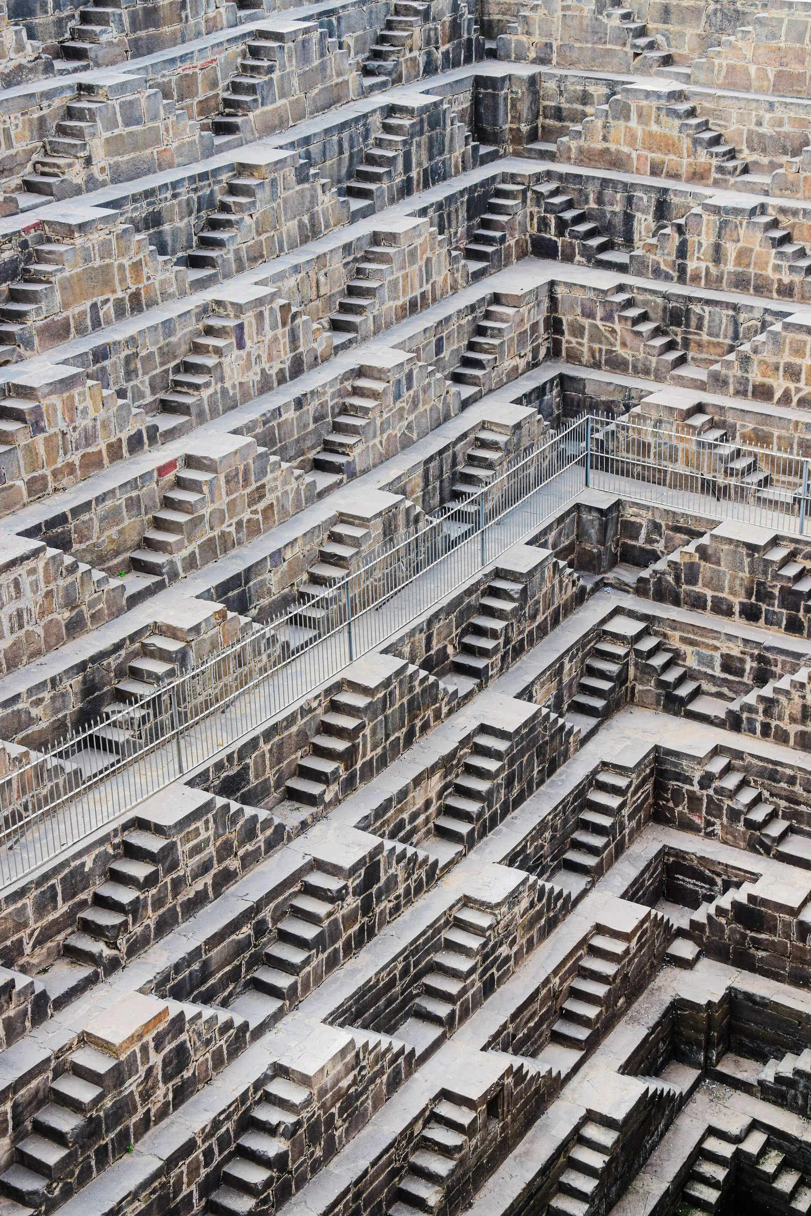 The stepped stone walls of the Chand Baori stepwell at Abhaneri in Rajasthan descend in repeating flights.