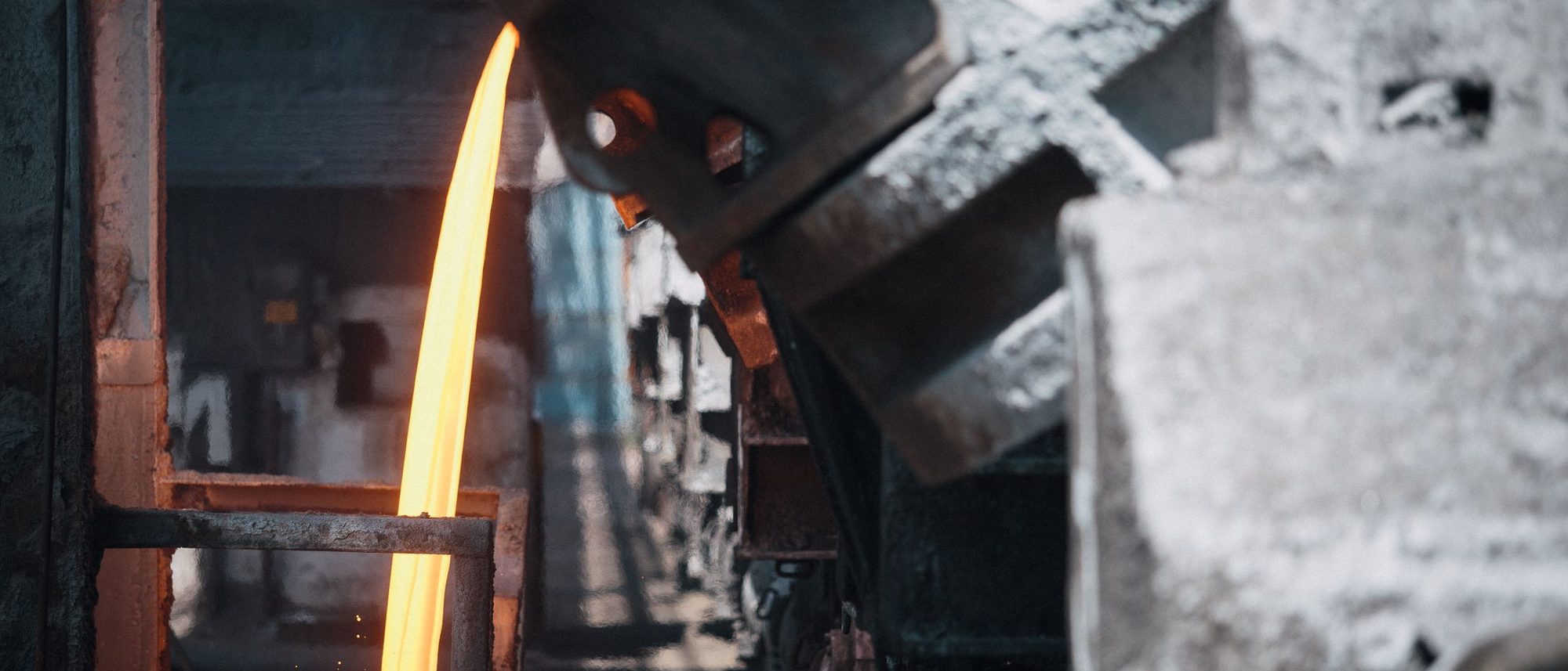 Molten metal pouring from vats on wagons inside a steelworks.