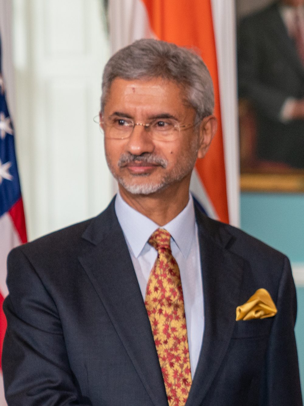 S. Jaishankar in a dark suit and patterned tie in front of the Indian and American flags
