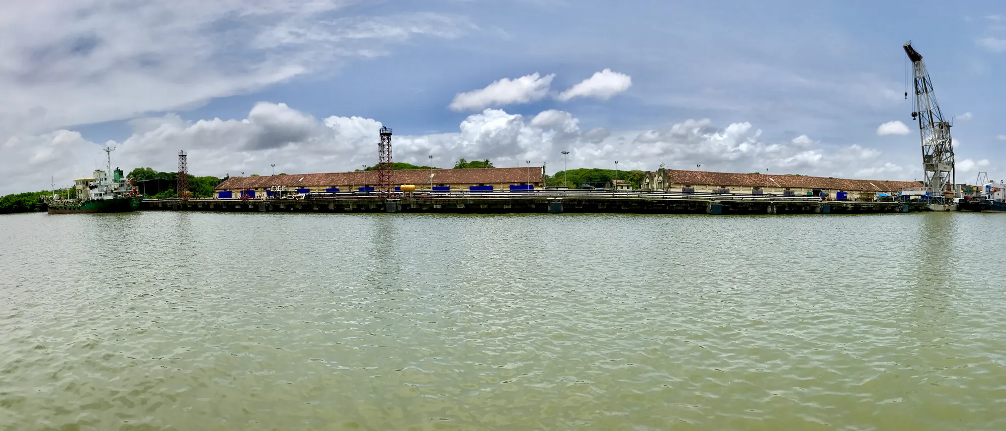 Ships moored along the quays of Cochin Shipyard in Kochi under cranes