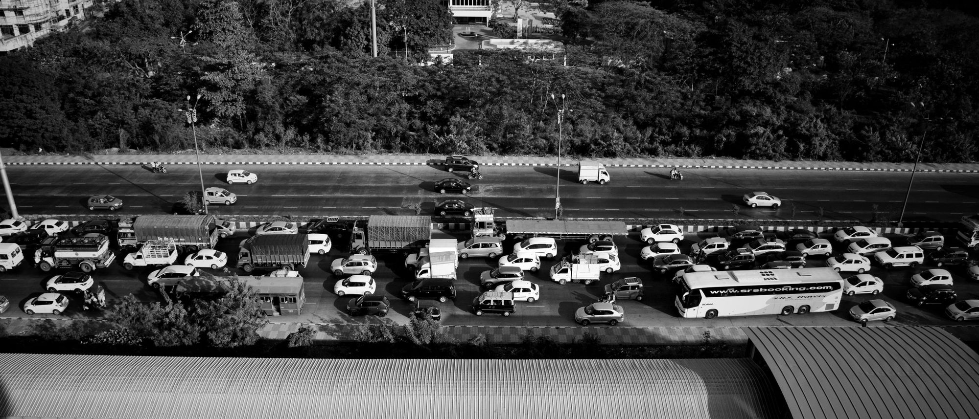 Aerial black and white view of cars and trucks packed in a traffic jam on a Mumbai expressway.