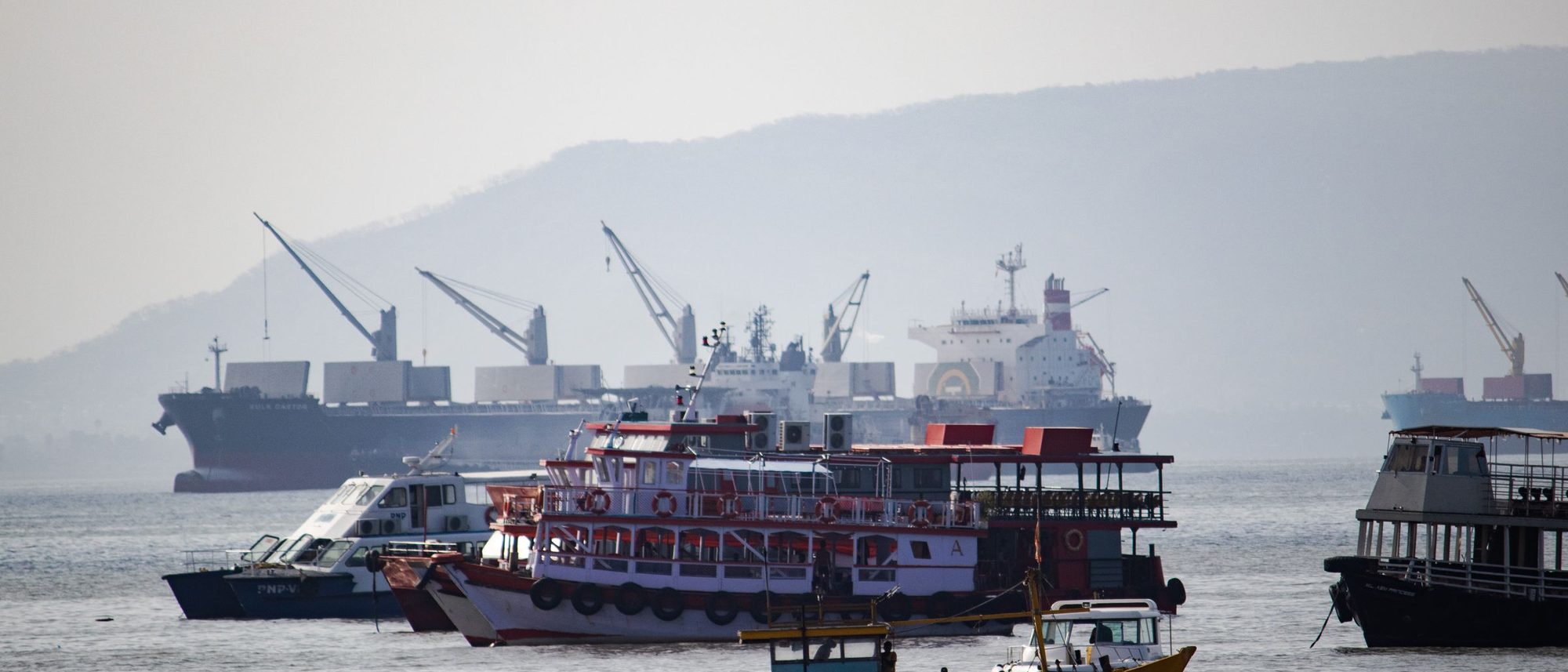 Boats and a cargo ship at anchor in the Arabian Sea off Mumbai.