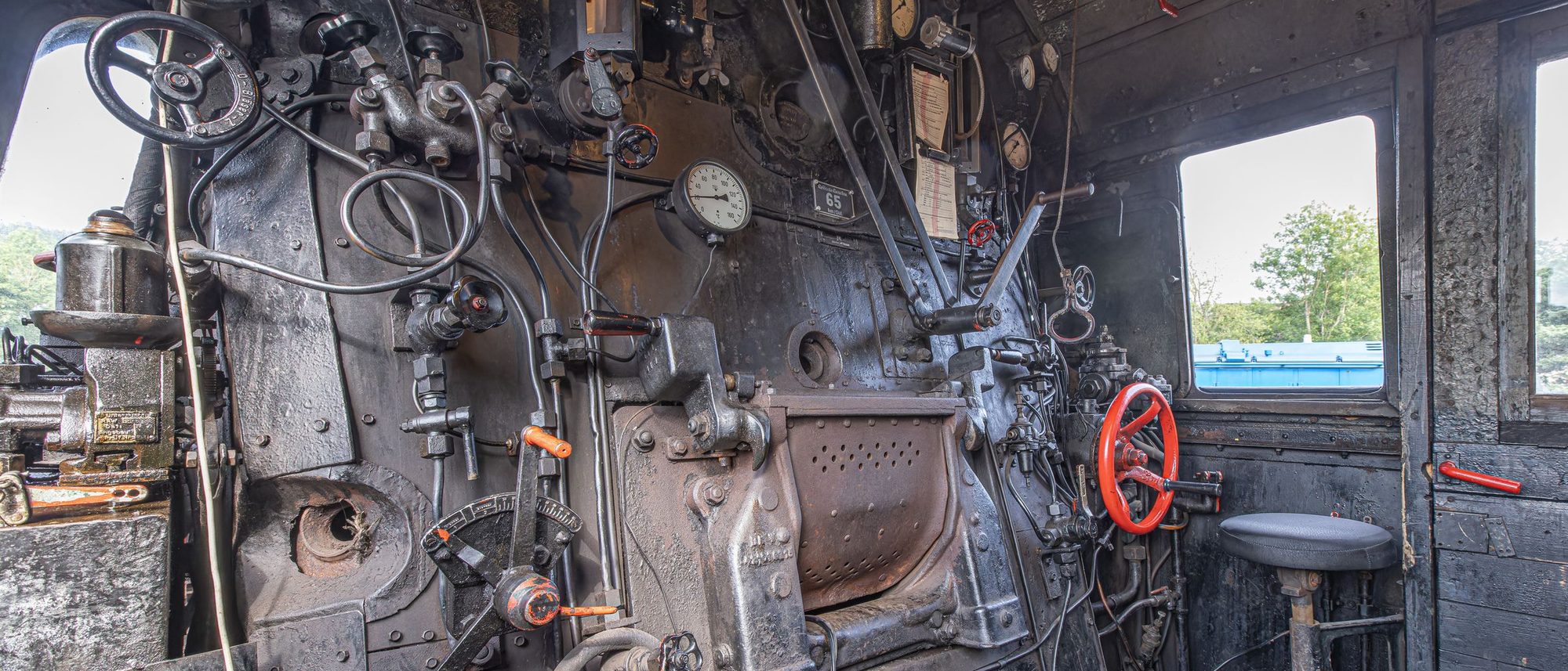 The controls and levers inside the cab of a vintage German locomotive.