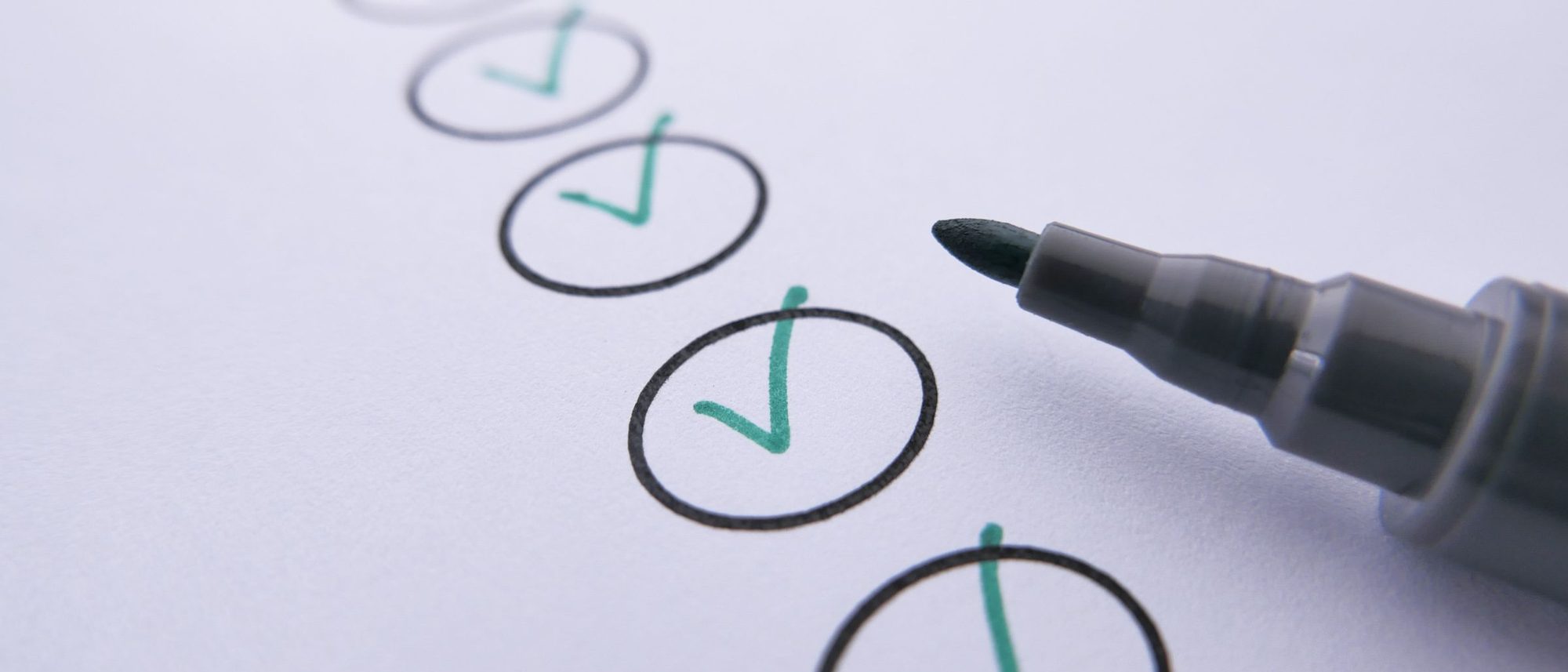 A marker beside a row of hand-ticked circles on white paper