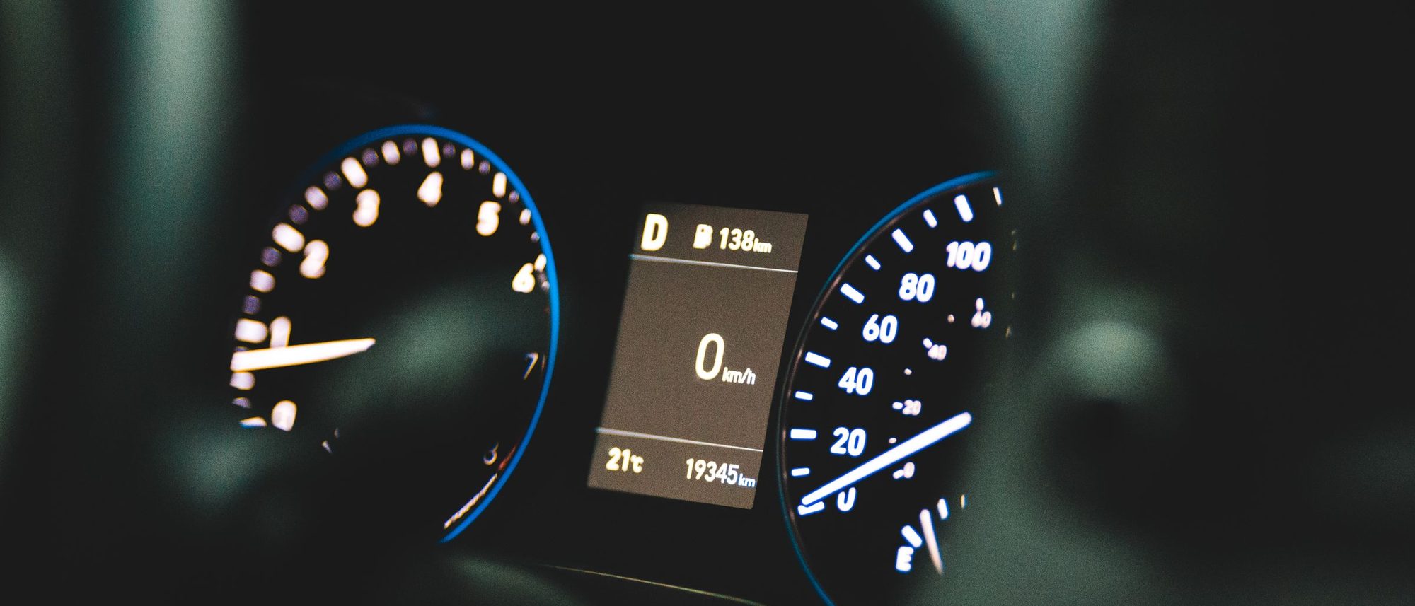 A car dashboard showing the speedometer at zero beside a large odometer reading.
