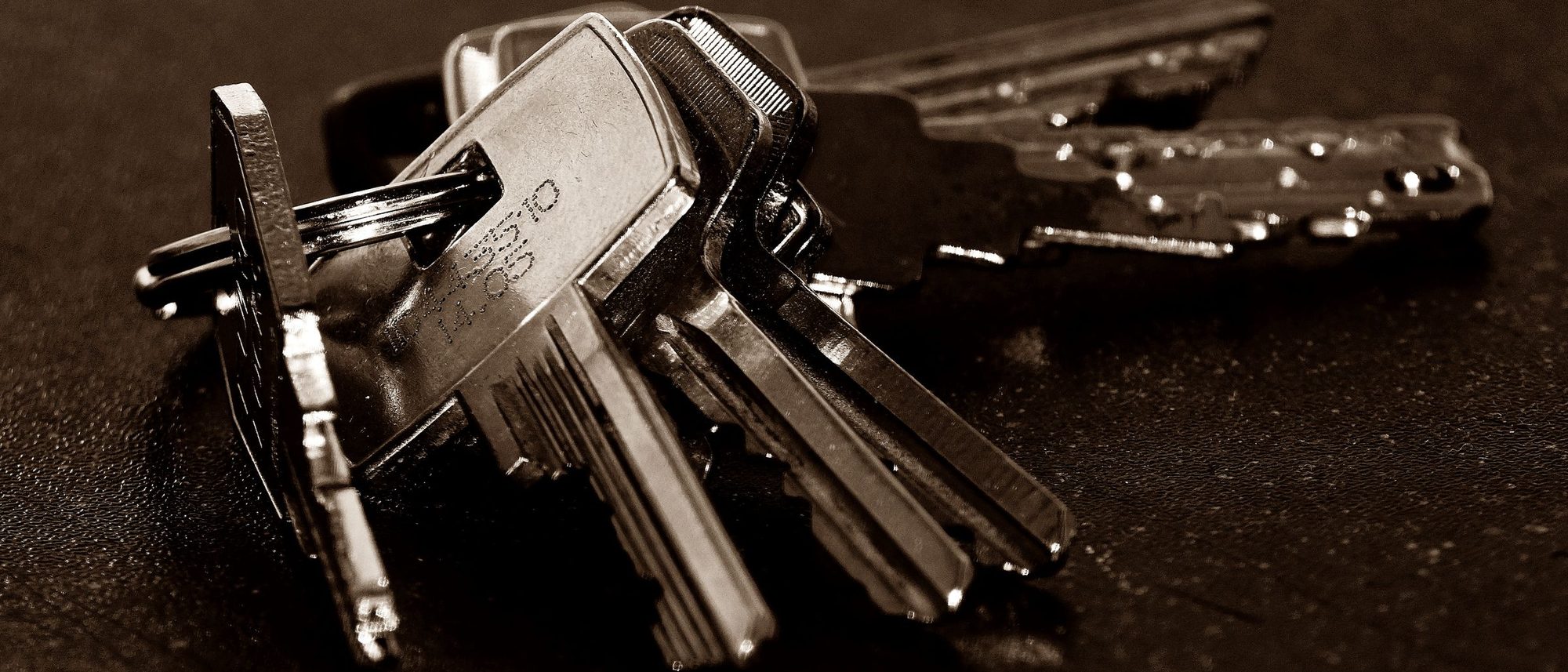 A bunch of house keys on a dark textured surface